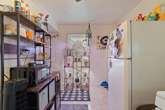 4621 Crockett St, Amarillo, TX 79110 - kitchen featuring freestanding refrigerator, light tile patterned flooring, and dark countertops