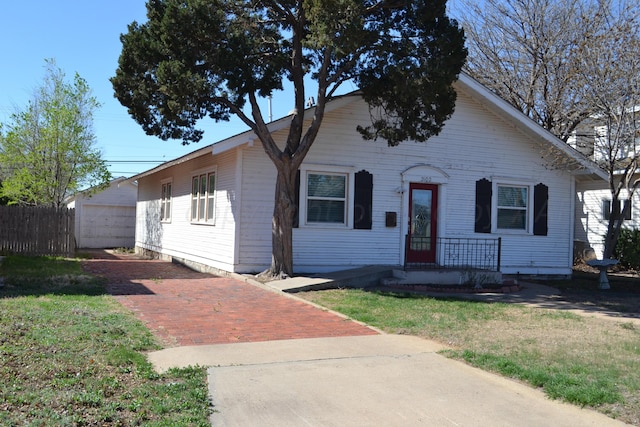 view of front of house featuring a front yard, a garage, and an outbuilding