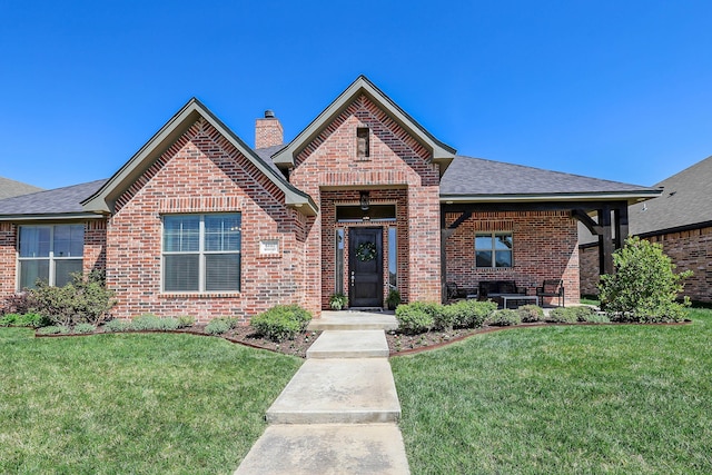 6107 Bowery, Amarillo, TX 79119 - view of front facade featuring brick siding, a chimney, a front yard, and roof with shingles