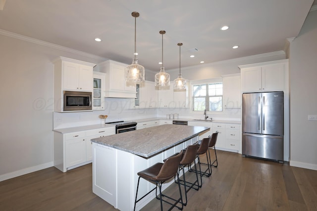 6107 Bowery, Amarillo, TX 79119 - kitchen with appliances with stainless steel finishes, a sink, white cabinets, a center island, and ornamental molding