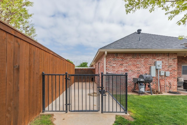 view of gate with fence and a lawn