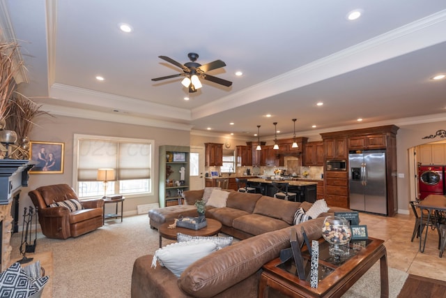 living room with recessed lighting, a raised ceiling, ornamental molding, washer / dryer, and ceiling fan