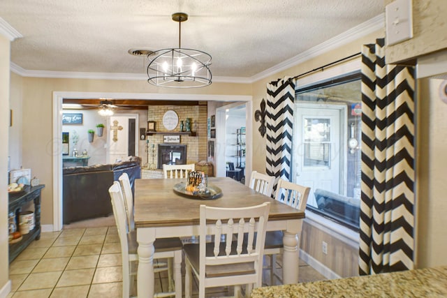 dining space featuring ornamental molding, a fireplace, a textured ceiling, light tile patterned floors, and ceiling fan with notable chandelier