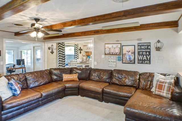 living room with beam ceiling, ceiling fan, and plenty of natural light