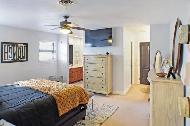 bedroom with light carpet, ceiling fan, and connected bathroom