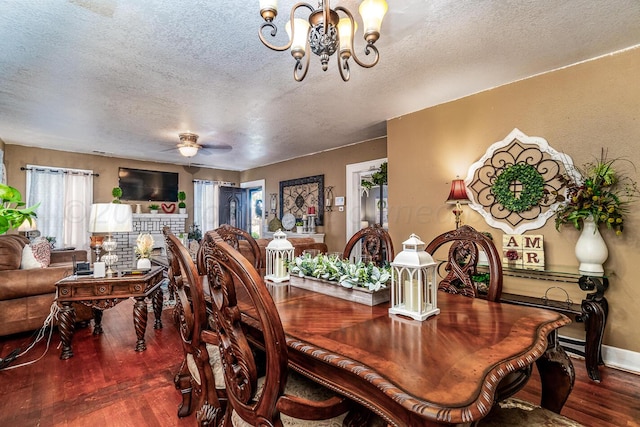 dining space featuring wood-type flooring, a textured ceiling, and ceiling fan with notable chandelier