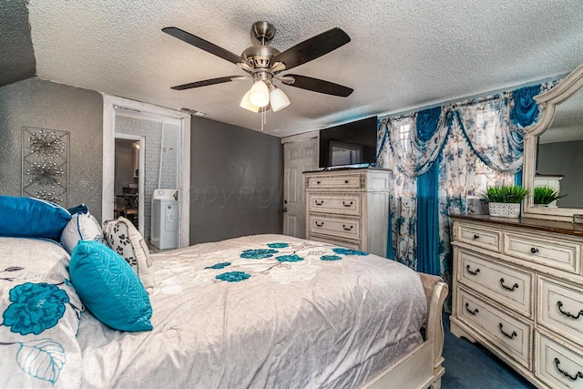 bedroom featuring a textured ceiling, connected bathroom, carpet, ceiling fan, and washer / dryer