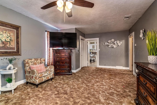 sitting room featuring ceiling fan, a textured ceiling, and carpet flooring