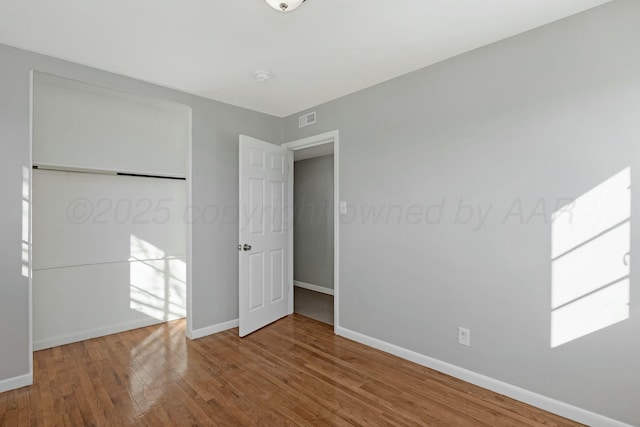 unfurnished bedroom with wood-type flooring and a closet