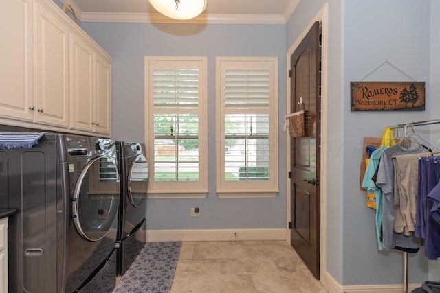 laundry room featuring washing machine and dryer, cabinets, and ornamental molding