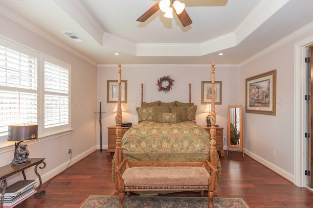 bedroom featuring ceiling fan, crown molding, dark hardwood / wood-style flooring, and a tray ceiling