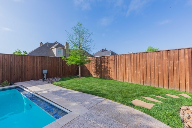 view of pool featuring a patio and a yard