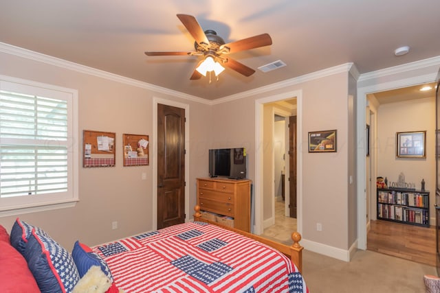 bedroom with light colored carpet, ceiling fan, and crown molding