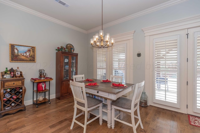 dining area featuring a wealth of natural light, hardwood / wood-style flooring, and an inviting chandelier