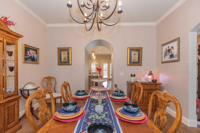 dining room featuring an inviting chandelier, sink, wood-type flooring, and ornamental molding