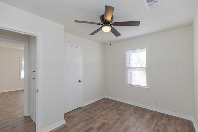 spare room featuring dark wood-type flooring and ceiling fan