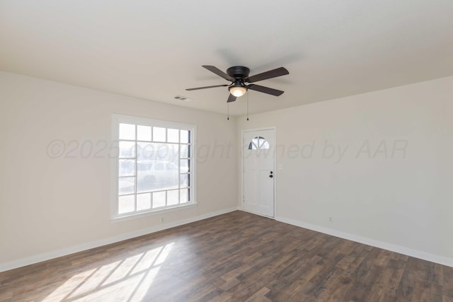 spare room with dark wood-type flooring and ceiling fan