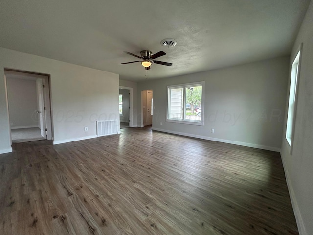 1223 Keeler Ave, Dalhart, TX 79022 - empty room featuring visible vents, a ceiling fan, dark wood finished floors, and baseboards