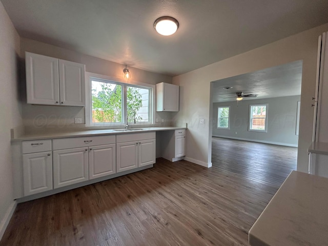 1223 Keeler Ave, Dalhart, TX 79022 - kitchen featuring light countertops, white cabinetry, a sink, and wood finished floors