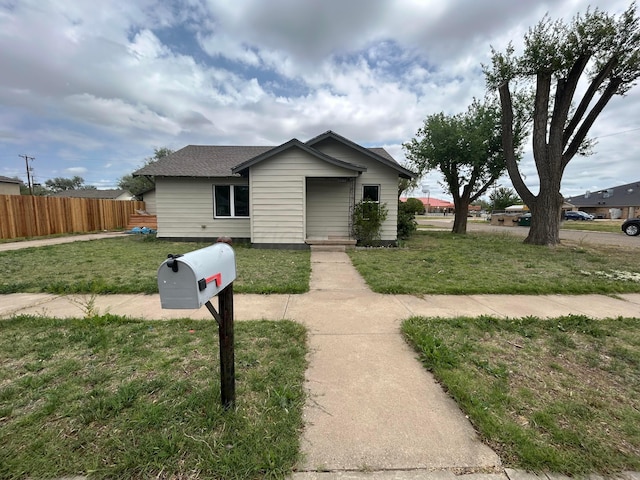 1223 Keeler Ave, Dalhart, TX 79022 - bungalow-style home with fence, roof with shingles, and a front lawn