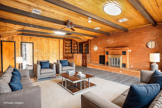 1802 Chama St, Amarillo, TX 79102 - living area with wood finished floors, a brick fireplace, brick wall, a ceiling fan, and a wooden ceiling with exposed beams