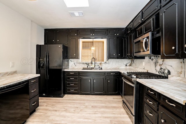 1802 Chama St, Amarillo, TX 79102 - kitchen featuring black appliances, dark cabinetry, light wood finished floors, and decorative backsplash
