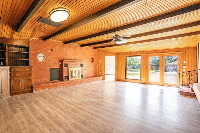 1802 Chama St, Amarillo, TX 79102 - unfurnished living room featuring wood finished floors, a ceiling fan, a fireplace, wood walls, and a wooden ceiling with exposed beams