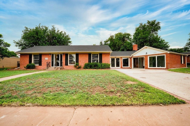 1802 Chama St, Amarillo, TX 79102 - ranch-style house featuring concrete driveway, brick siding, a front yard, and a chimney