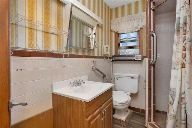 709 Franklin Ave, Panhandle, TX 79068 - bathroom featuring wallpapered walls, a shower stall, toilet, vanity, and a wainscoted wall
