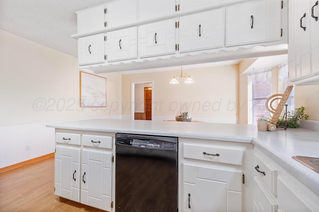 kitchen featuring black dishwasher, light countertops, light wood-style flooring, and white cabinets
