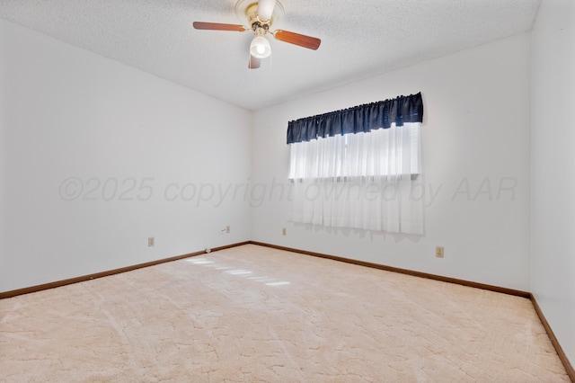 carpeted spare room with a textured ceiling, baseboards, and ceiling fan
