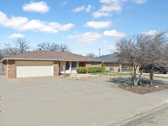 single story home with fence, an attached garage, brick siding, roof with shingles, and driveway