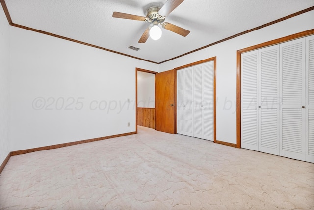 unfurnished bedroom with visible vents, carpet floors, and ornamental molding