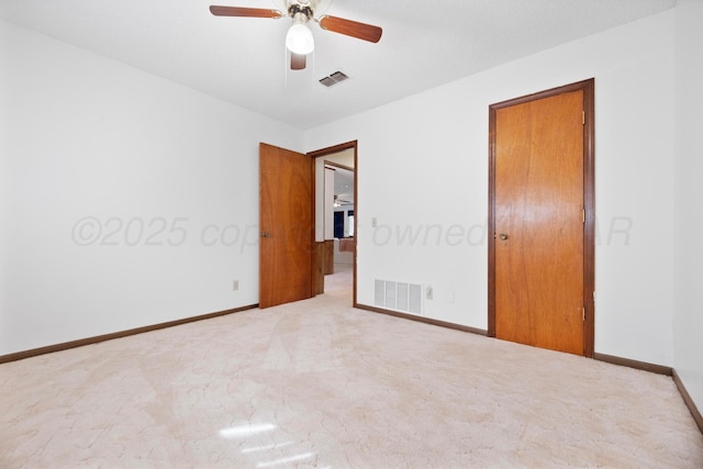 carpeted spare room featuring a ceiling fan, baseboards, and visible vents