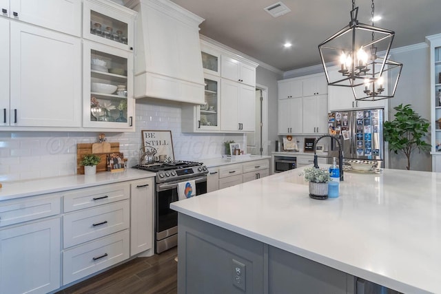 5904 Nancy Ellen St, Amarillo, TX 79119 - kitchen with appliances with stainless steel finishes, crown molding, light countertops, dark wood-type flooring, and decorative backsplash