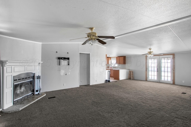 unfurnished living room featuring carpet, a textured ceiling, and ceiling fan