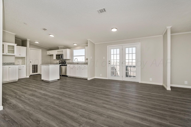 unfurnished living room with sink, crown molding, vaulted ceiling, a textured ceiling, and dark hardwood / wood-style floors