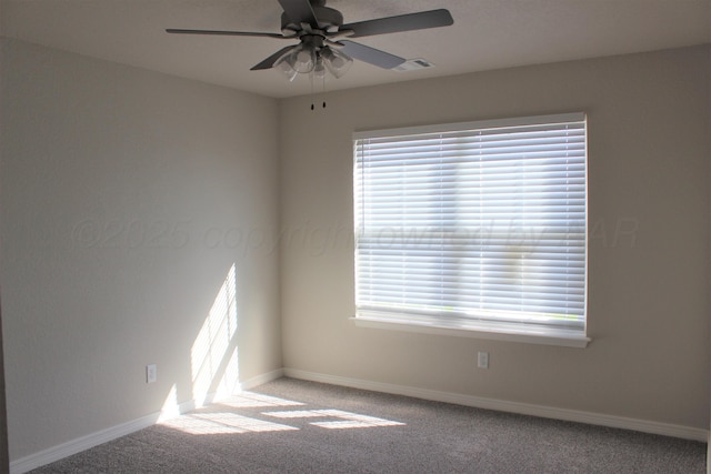 carpeted empty room featuring ceiling fan and a wealth of natural light