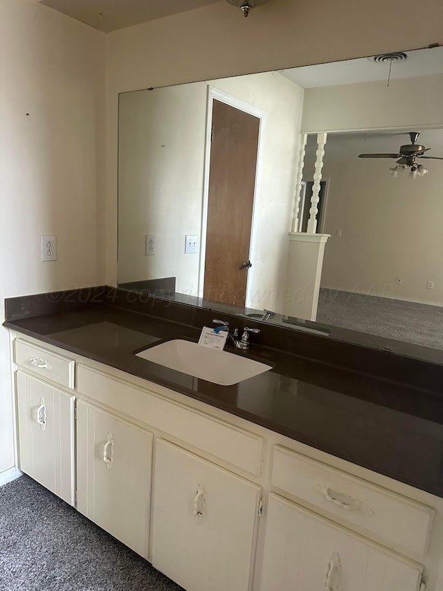 kitchen with dark colored carpet, ceiling fan, white cabinetry, and sink