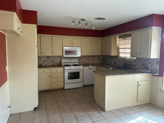 kitchen featuring kitchen peninsula, decorative backsplash, sink, and white appliances