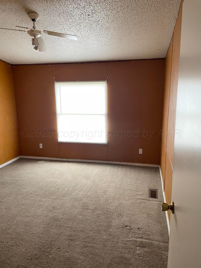 spare room with visible vents, a ceiling fan, baseboards, a textured ceiling, and carpet flooring