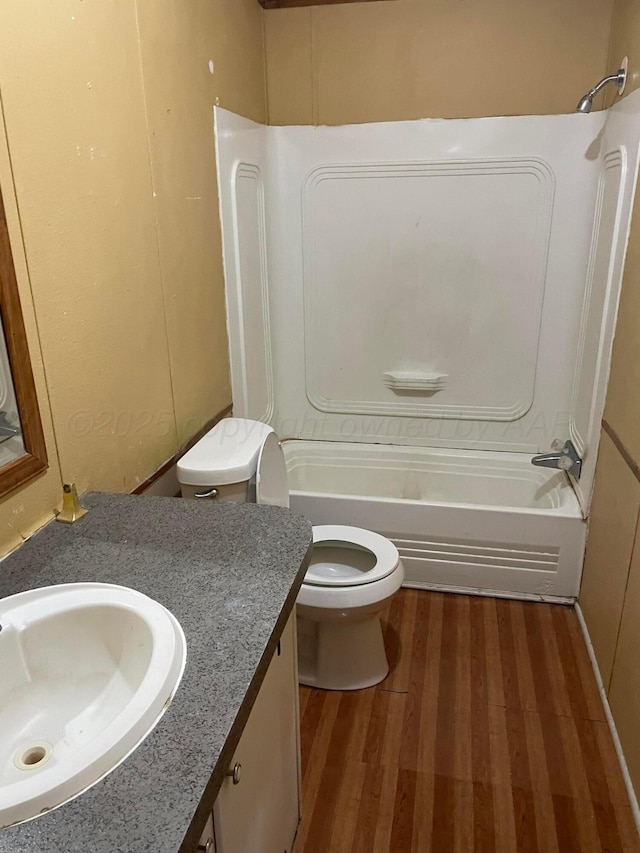 bathroom featuring shower / bathing tub combination, wood finished floors, toilet, and vanity