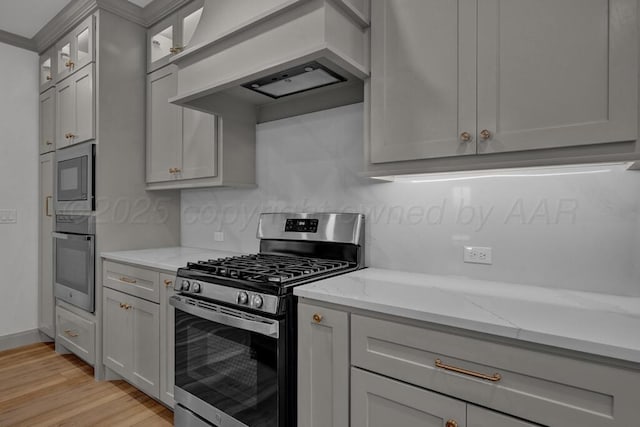 5505 Sheridan St, Amarillo, TX 79119 - kitchen with appliances with stainless steel finishes, premium range hood, light wood-style flooring, light stone countertops, and glass insert cabinets
