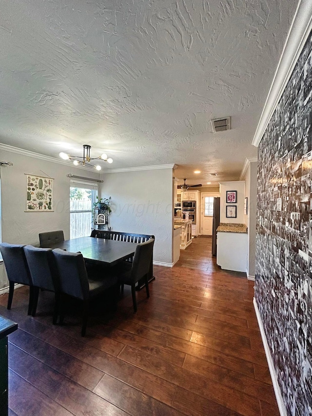 dining space with dark wood-style flooring, visible vents, crown molding, and a textured ceiling