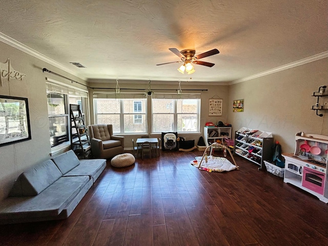 living area with a textured ceiling, ornamental molding, a ceiling fan, and wood finished floors