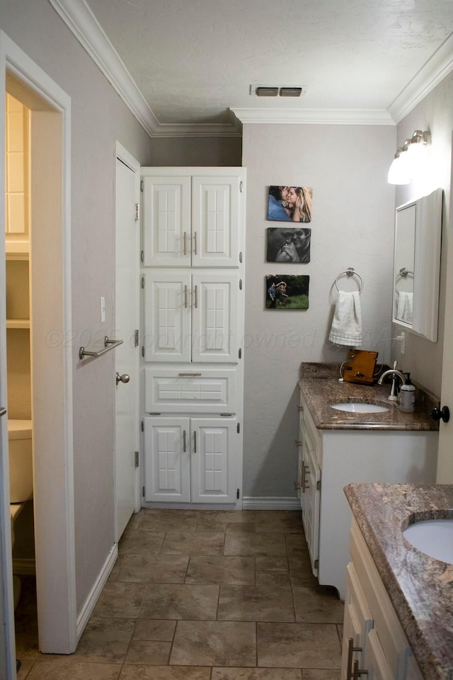 bathroom with two vanities, visible vents, a sink, and crown molding