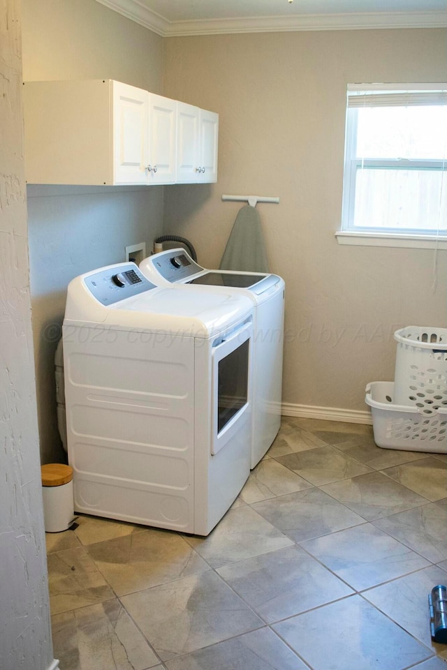 clothes washing area with washing machine and clothes dryer, baseboards, ornamental molding, and cabinet space