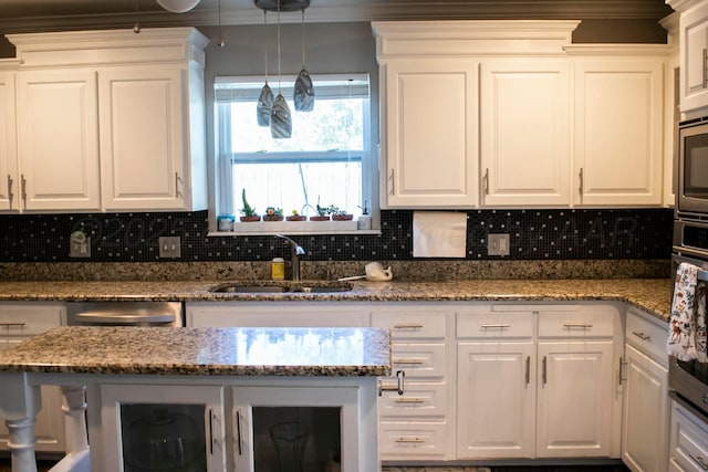 kitchen featuring a sink, backsplash, and white cabinets