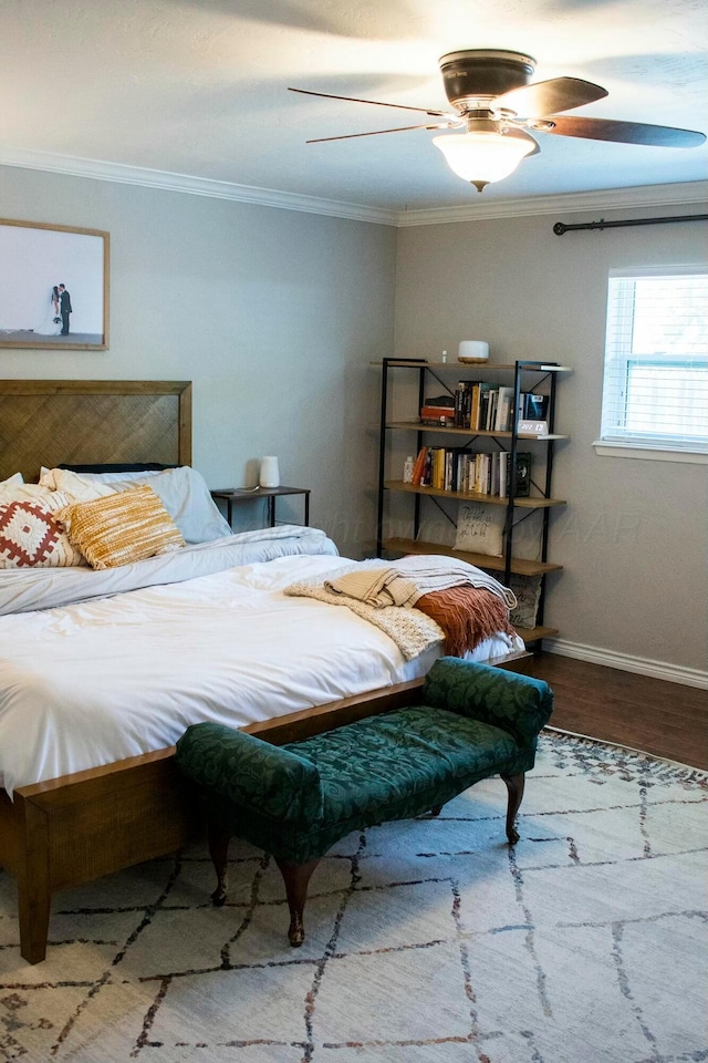 bedroom featuring baseboards, crown molding, a ceiling fan, and wood finished floors