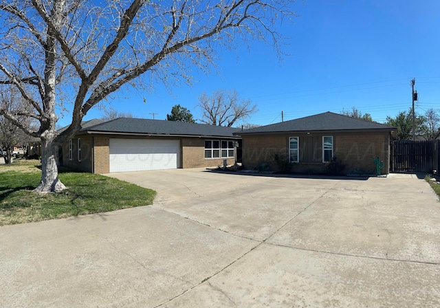 ranch-style home featuring concrete driveway, brick siding, fence, and an attached garage